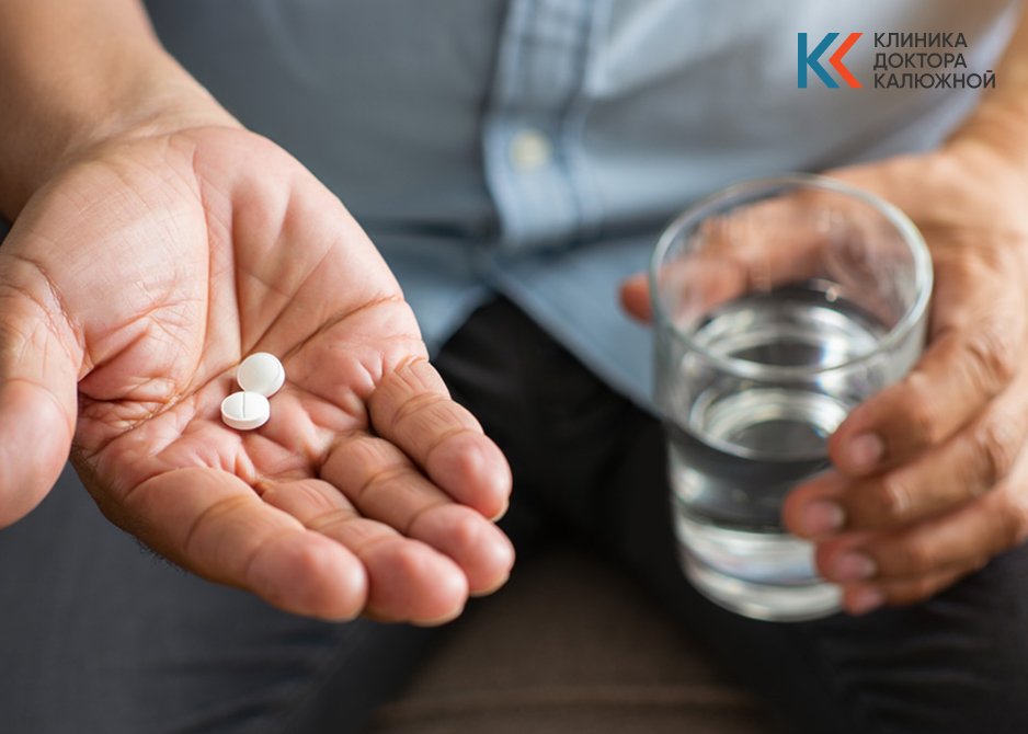 Мужчина держит таблетки в руках